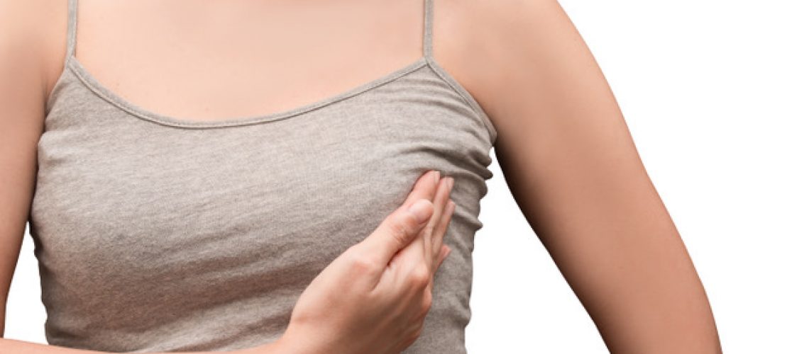 Frau mit Brustentzündung tastet ihre entzündete Brust